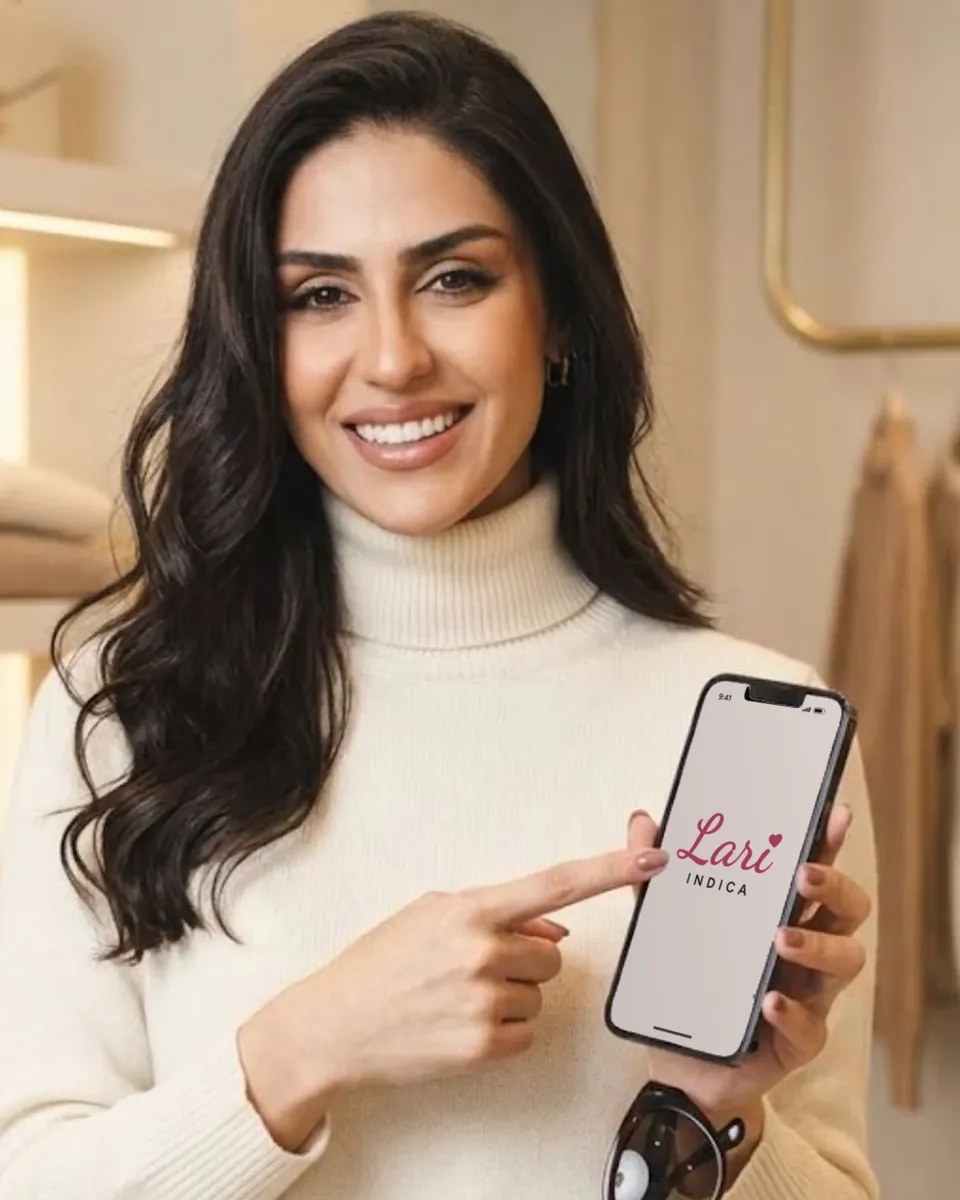 A Lari sorrindo e apontando para a logo do grupo na tela do celular